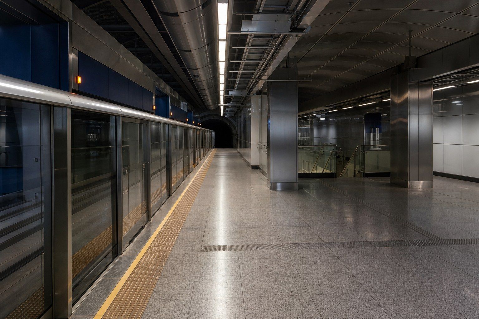 An empty underground Mass Rapid Transit platform in Singapore, platform screen doors closed, tiled floor under cool fluorescent light.